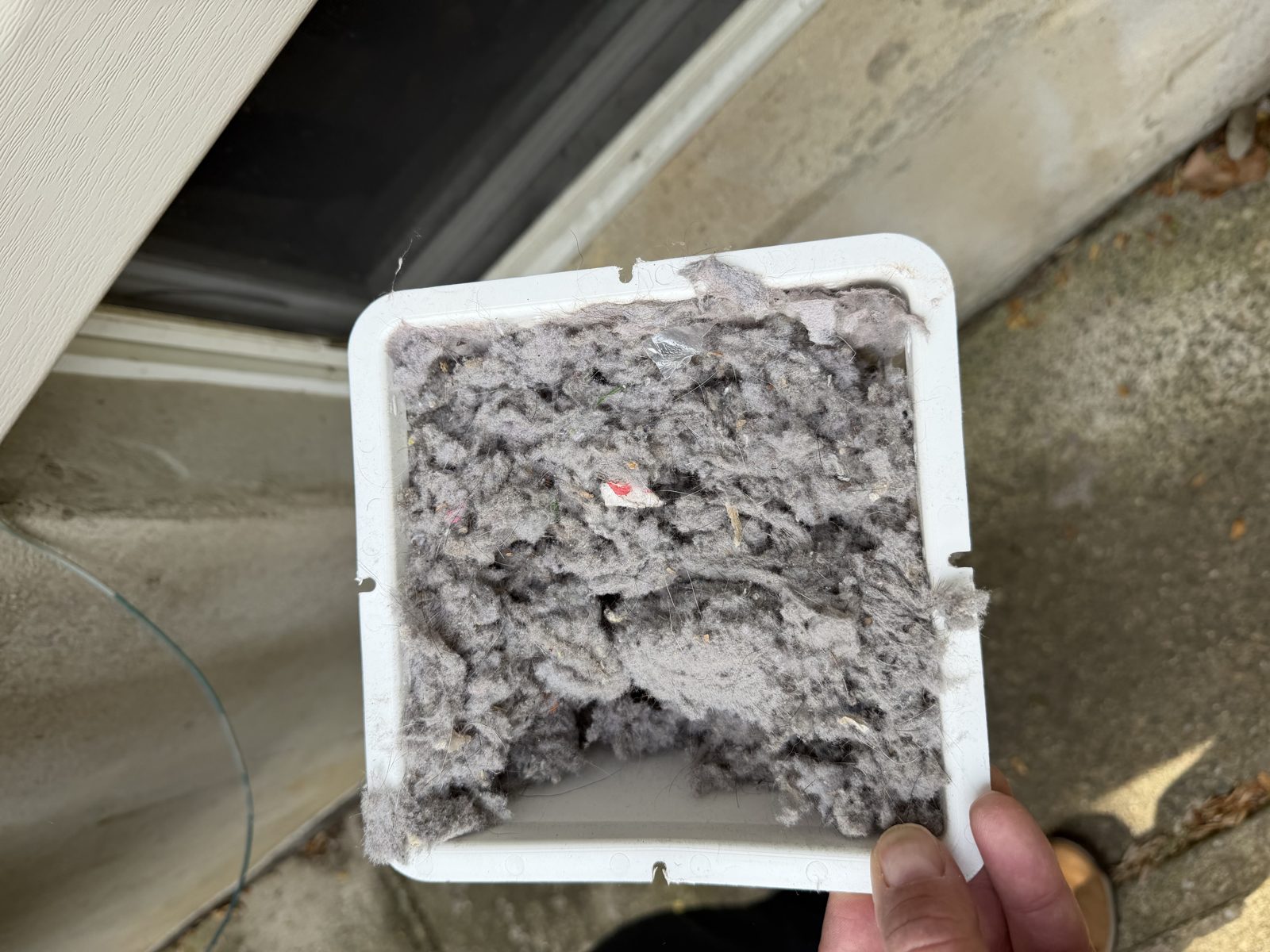 A vent cover full of lint held by an AMG technician. AMG at work for homes in Rockaway, New Jersey.