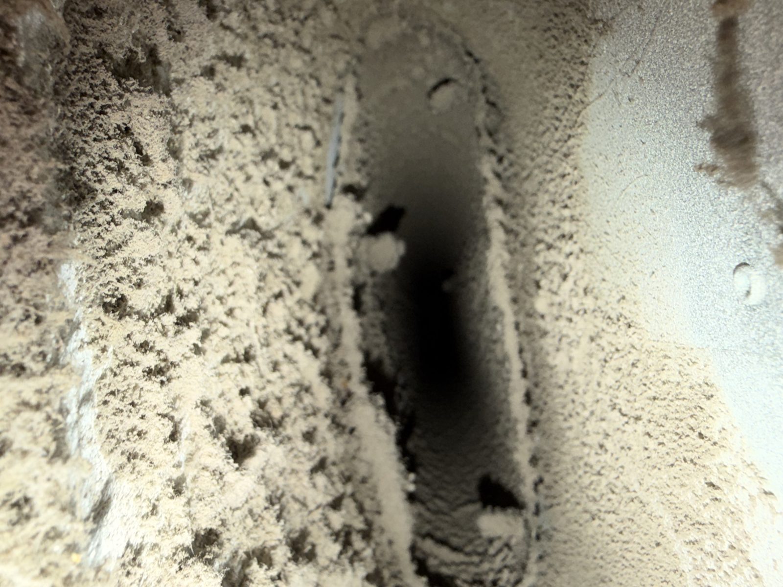 Heavy dust inside a duct before AMG cleaning. AMG at work for homes in Irvington, New Jersey.