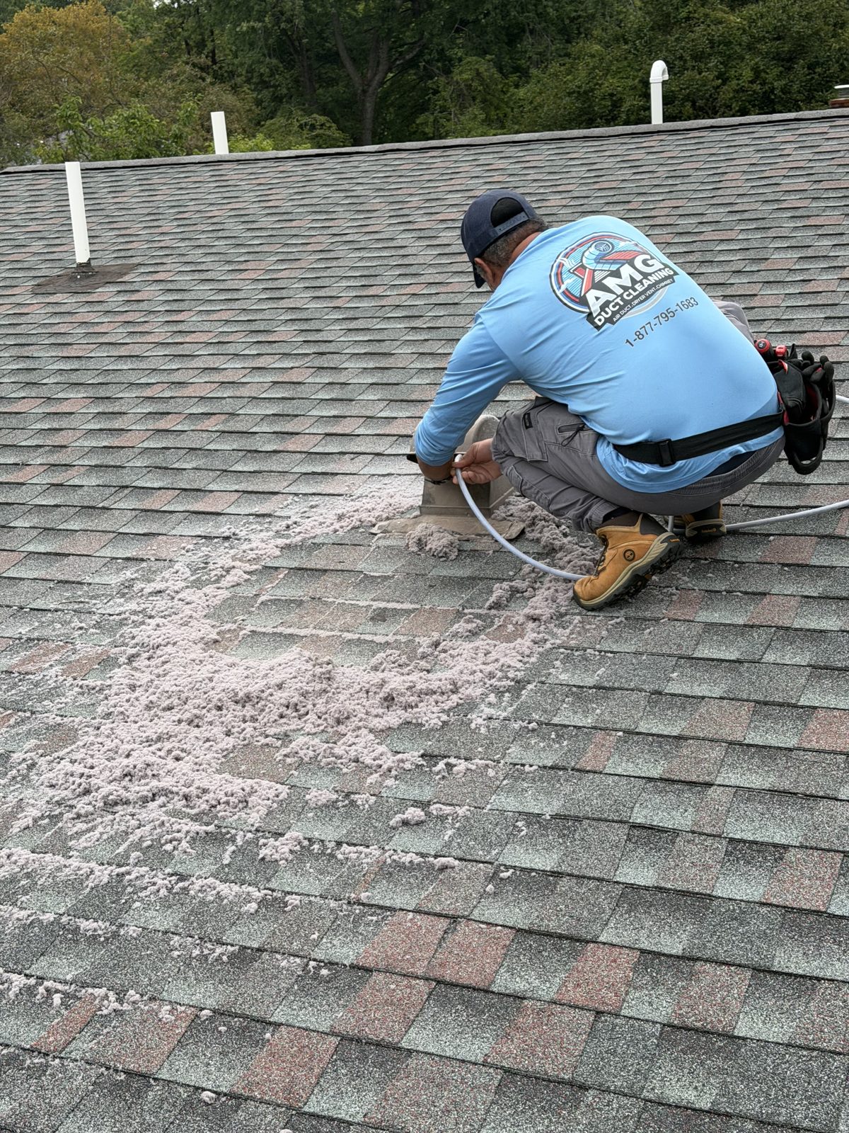 An AMG technician cleaning a vent on a roof. AMG at work for homes in Maplewood, New Jersey.