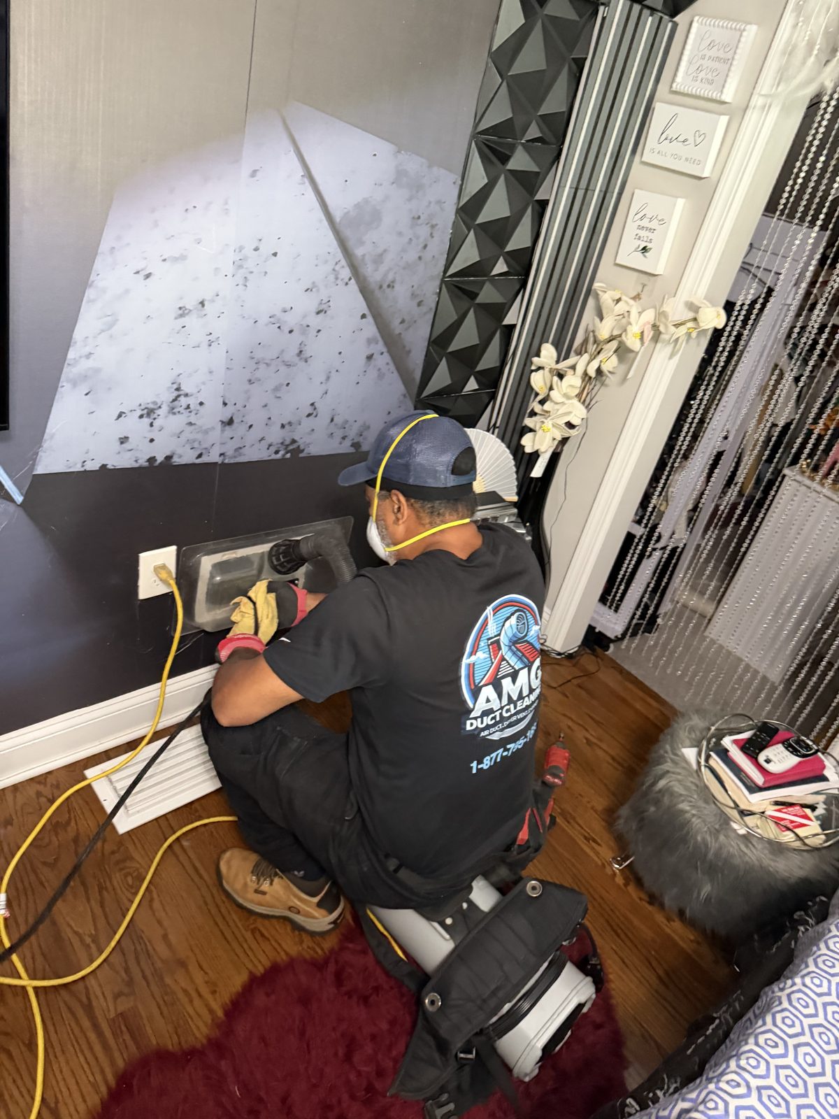 An AMG technician servicing a duct inside a home. AMG at work for homes in Little Falls, New Jersey.