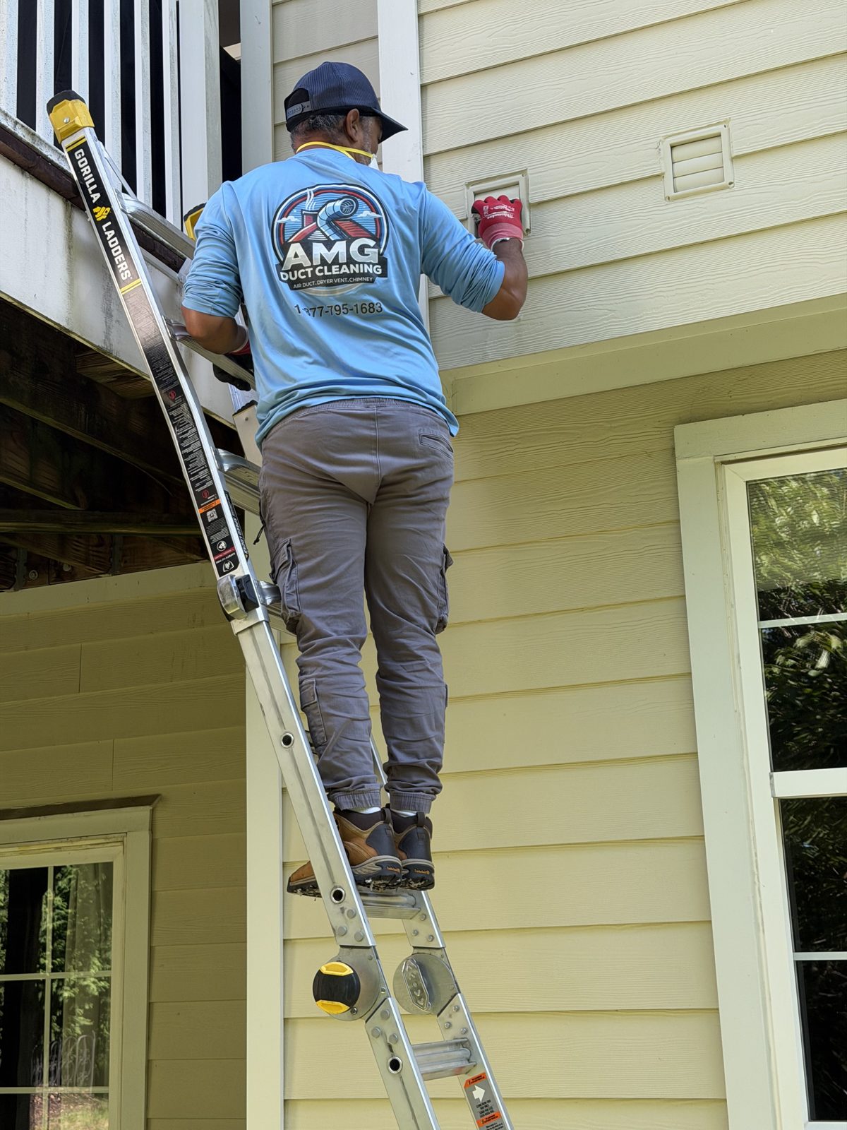 An AMG technician on a ladder at a home exterior. AMG at work for homes in Westfield, New Jersey.